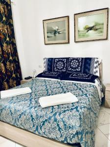 a bedroom with a blue and white bed with two pillows at CASA DEI FIORI in Somma Lombardo