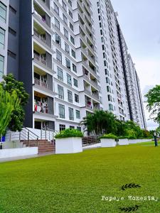 a large apartment building with a green lawn in front of it at Luxury Premium Suite @ Kempas Johor Bahru in Johor Bahru