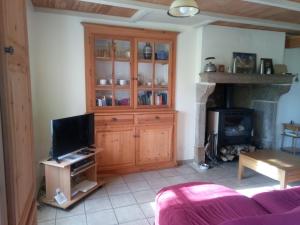 een woonkamer met een tv en een open haard bij chantacalme in Montboissier