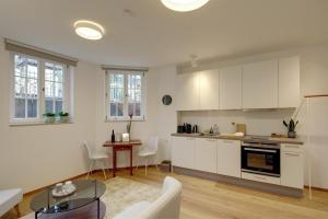 a kitchen with white cabinets and a table in a room at Boutique Apartments Freiburg - Elisabeth in Freiburg im Breisgau