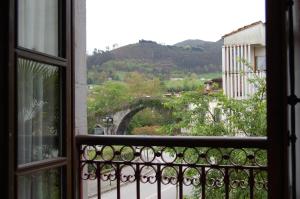 a view from a balcony of a building with a view of a river at Puente Romano in Cangas de Onís