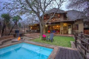 a house with a swimming pool in front of a house at Lovely holiday home bordering Kruger National Park in Marloth Park