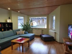 ein Wohnzimmer mit einem blauen Sofa und einem Tisch in der Unterkunft Kaare Guesthouse in Viljandi
