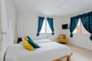 1 dormitorio con 2 camas con cortinas azules en Appartement nature, en Thônes