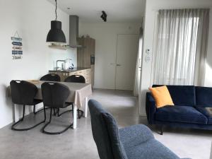 a living room with a table and a blue couch at Hendrikhof Appartement 3 ‘het Gebint’ in Westkapelle