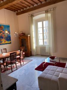 a living room with a table and a couch at Renovated apartment with 3 bedrooms in an historic palazzo between port and old town in Livorno