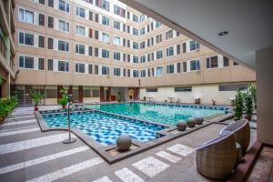 a swimming pool in front of a building at Comfy Studio Apartment By REQhome in Bandung