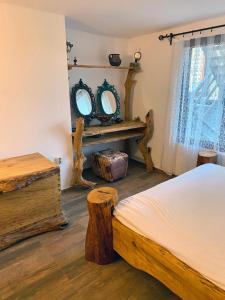 um quarto com uma cama e dois espelhos e troncos em Sinemoria Guest House em Sinemorets