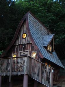 Una casa con un reloj al costado. en Hexenhäuschen am Waldrand, en Annweiler am Trifels