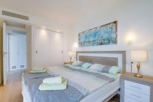 ein weißes Schlafzimmer mit einem großen Bett mit zwei Kissen in der Unterkunft Sa Maniga 6F in Cala Millor