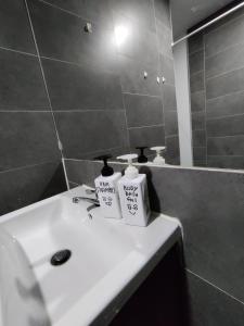 een badkamer met een witte wastafel en een spiegel bij Ava Empire Damansara Modern High Floor Great Views in Petaling Jaya
