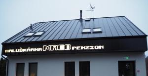 a black and white building with a sign on it at Penzion Maco Buchlovice in Buchlovice