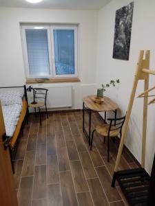 ブフロヴィツェにあるPenzion Maco Buchloviceの椅子2脚、テーブル、窓が備わる客室です。