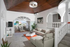 een woonkamer met witte meubels en een houten plafond bij Orient Bay Villa Rentals St Martin in Orient Bay