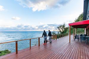 two people standing on a deck looking at the ocean at 勝浦最南端の岬パワースポット天 in Katsuura