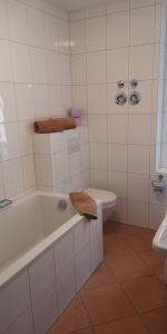 baño blanco con bañera y aseo en Ferienwohnung Simon, en Füssen