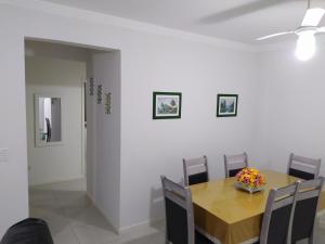 a dining room with a wooden table and chairs at AP Itapema in Itapema