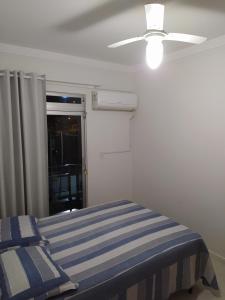 una camera con letto e ventilatore a soffitto di AP Itapema a Itapema