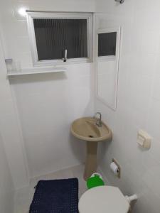 a small bathroom with a sink and a toilet at AP Itapema in Itapema +8 photos