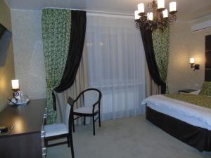 Habitación de hotel con cama, escritorio y silla en Domashny Ochag, en Ujtá