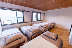 una camera con diversi posti letto in una stanza con vista sull'oceano di 勝浦最南端の岬パワースポット天 a Katsuura Altre 96 foto