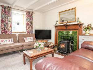 a living room with a couch and a fireplace at Corner Cottage in Cemaes Bay