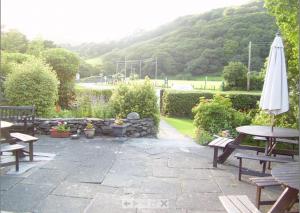 a patio with a table and an umbrella at The Dolgoch in Bryn-crug
