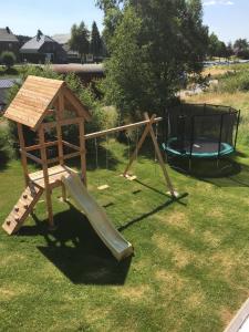 einen Holzspielplatz mit Rutsche und Pavillon in der Unterkunft Rod Hus in Sourbrodt