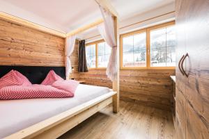 ein Schlafzimmer mit einem Bett mit roten Kissen darauf in der Unterkunft Gitschberg - Appartements in Vintl
