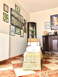 salon z wiklinowym krzesłem i obrazami na ścianie w obiekcie Villa Apartament Nad Zalewem Gołdap w Gołdapi