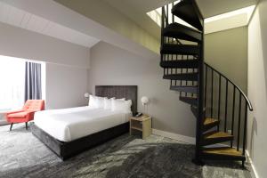 Habitación de hotel con cama y escalera de caracol en Lake Placid Inn Boutique Hotel, en Lake Placid