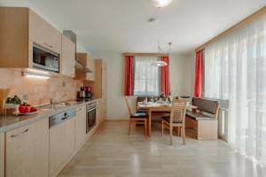 cocina con mesa y comedor en 4 Mountains Apartments en Kleinarl