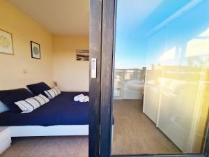 a bedroom with a bed and a glass door at Le penthouse de Kelly in Koksijde