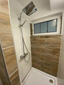 ein kleines Bad mit einer Dusche und einem Fenster in der Unterkunft Schönes Apartment mit Terrasse, mitten im Grünen Stattegg in Stattegg