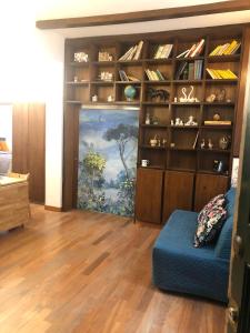 a living room with a book shelf and a blue couch at Sofia guest house in Rome