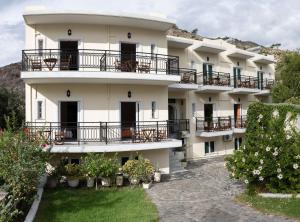 a large white building with balconies and plants at Aretousa in Sougia