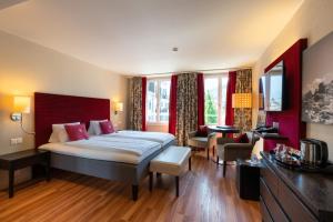 a bedroom with a large bed and a living room at Hotel Krebs Interlaken in Interlaken