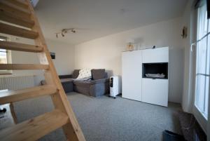 - un salon avec un escalier et un canapé dans l'établissement Ferienhaus Nordstrand, à Altenkirchen