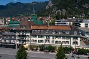 un edificio in una città con una montagna sullo sfondo di Hotel Krebs Interlaken a Interlaken