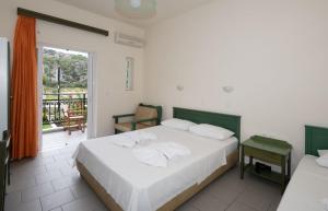 a bedroom with a large bed and a balcony at Aretousa in Sougia