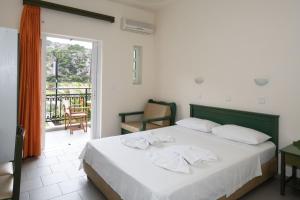 a bedroom with a bed with towels on it at Aretousa in Sougia