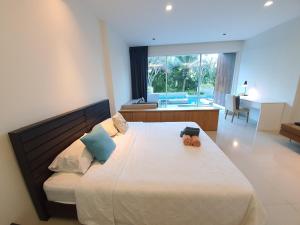 een slaapkamer met een groot bed en een groot raam bij Mida de Sea Residence Hua Hin in Cha Am