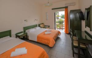 a hotel room with two beds and a balcony at Aretousa in Sougia