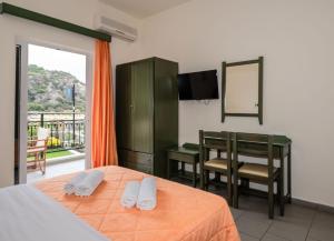 a bedroom with a bed and a table and a mirror at Aretousa in Sougia