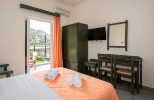 a bedroom with a bed and a table and chairs at Aretousa in Sougia