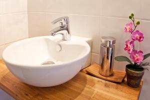 a white sink on a wooden counter with flowers at Söråkers Timrå Herrgård in Söråker