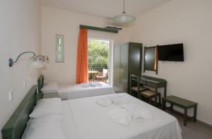 a hotel room with two beds and a television at Aretousa in Sougia