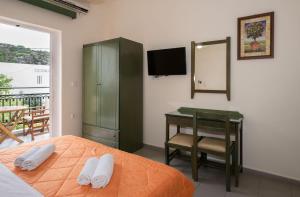 a bedroom with a bed and a desk and a mirror at Aretousa in Sougia