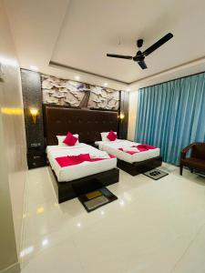 a bedroom with two beds and a ceiling fan at Blue Diamond Resort & Hotel in Muzaffarpur