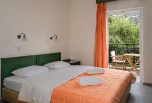 a bedroom with a bed with two towels on it at Aretousa in Sougia